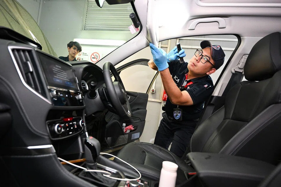 Sergeant Muhammad Shahrul Alqaff Mohammad Juri conducting a vehicle check under the supervision of Checkpoint Inspector Dayangku Suhaila Abdul Aziz (left) at Woodlands Checkpoint on Aug 4.