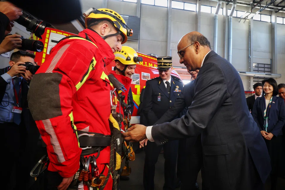 President Tharman Shanmugaratnam and Grand Duke Henri (just seen) meeting firefighters during a visit to the National Fire and Rescue Centre in Luxembourg, on March 28.