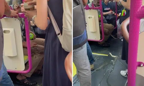 Woman's Starbucks drink spills on man's pants when bus stops suddenly, he uses water to clean it off