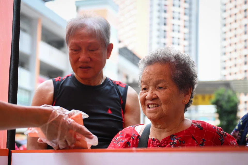 Madam Wong Mei Ngor receiving her free ice cream. ST PHOTO: SHINTARO TAY