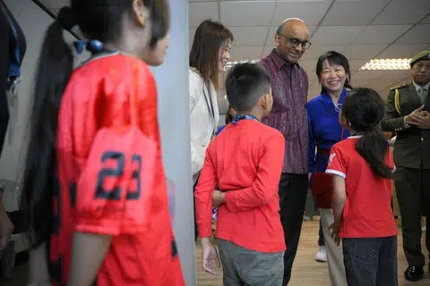 President Tharman Shanmugaratnam and his spouse, Ms Jane Ittogi, accompanied by Ms Lam Moi Kwai, chief executive of Life Community Services Society, speaking with beneficiaries of the society's Life! Mentors Programme at the Kallang ActiveSG Netball...