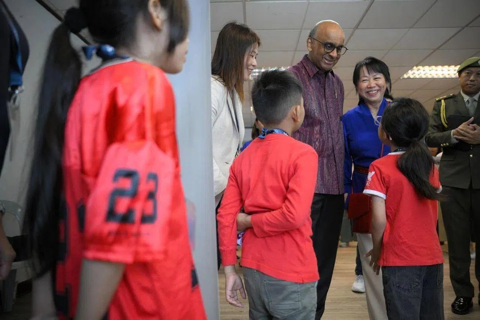 President Tharman Shanmugaratnam and his spouse, Ms Jane Ittogi, accompanied by Ms Lam Moi Kwai, chief executive of Life Community Services Society, speaking with beneficiaries of the society's Life! Mentors Programme at the Kallang ActiveSG Netball...