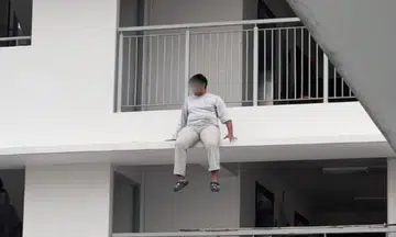 A man was arrested after being found sitting precariously on a HDB ledge.