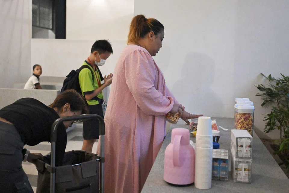 Ms Lydia Susiyanti (in pink) and Ms Halinah Yatim setting up the breakfast spread for primary school students on May 28.