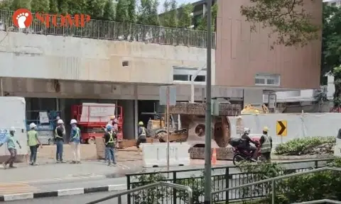 Excavator falls off trailer truck outside Bedok condo construction site
