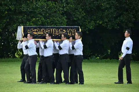 Pallbearers carrying the casket of Puan Noor Aishah Mohammad Salim at Kranji State Cemetery on April 22.