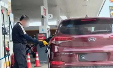 A man was seen holding a RON95 pump nozzle attached to a Singapore-registered car. 