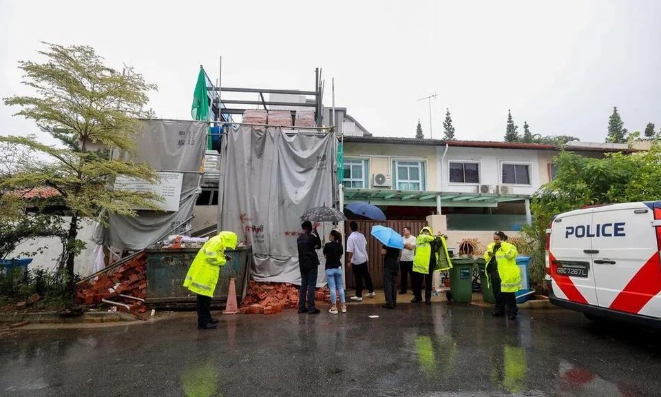 Police officers and investigators at Jalan Usaha after bricks placed on a completed canopy fell onto a worker at a house construction site on May 16.
