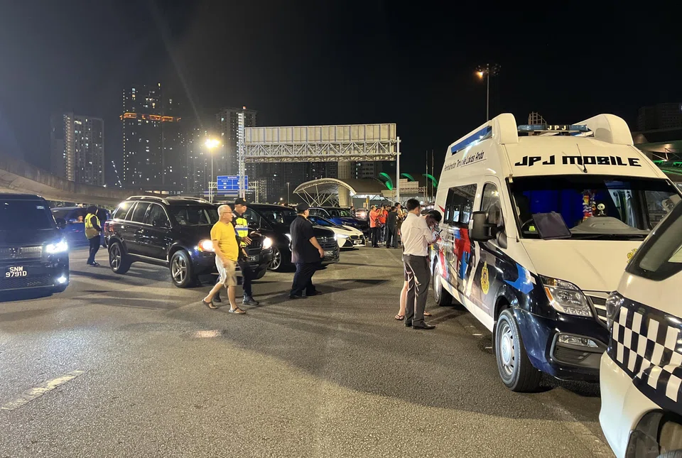 Officers from the Malaysian Road Transport Department seen pulling aside cars at the Johor-bound exit road of the Bangunan Sultan Iskandar CIQ complex.