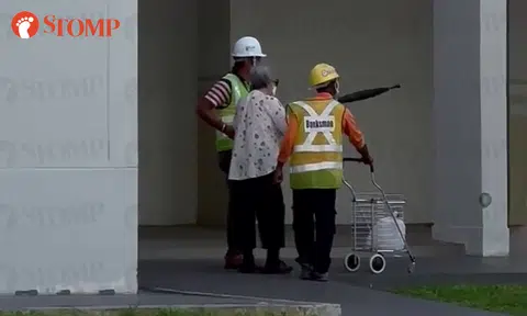 Kind workers help to walk elderly woman in Hougang, carry her trolley