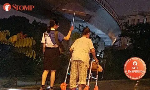 Schoolgirl uses umbrella to shelter elderly woman from rain -- even as her bag gets wet