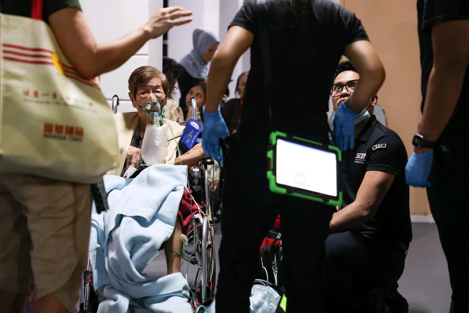 SCDF personnel assisting residents at the void deck of Block 172A, Toa Payoh Lorong 1, near the block where a unit caught fire.