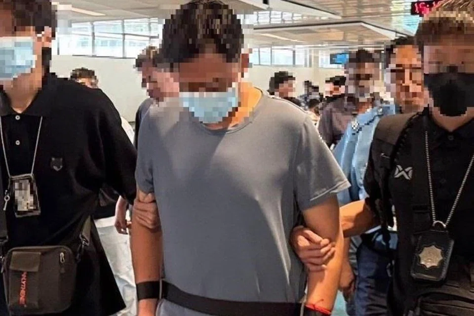 The 50-year-old man (centre) arrested by CNB officers on July 9.