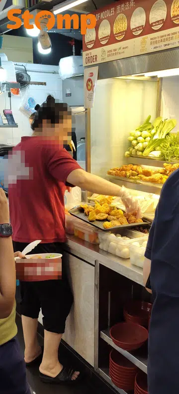 Ubi stall employee puts yong tau foo ingredients on tray