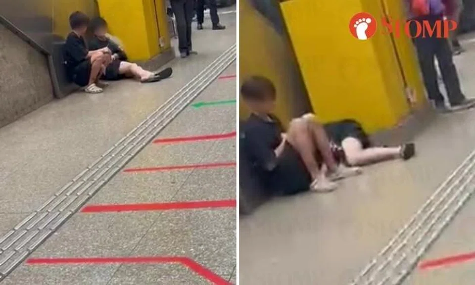 2 boys vape while sitting on Toa Payoh MRT platform, one curls up on floor next to friend