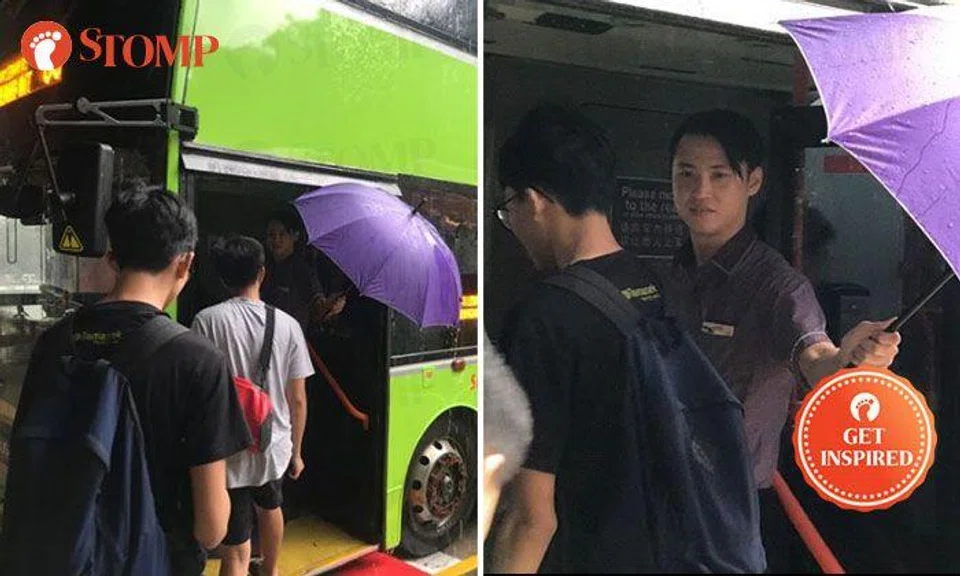 Handsome bus captain shelters commuters with umbrella during downpour at HarbourFront Bus Interchange