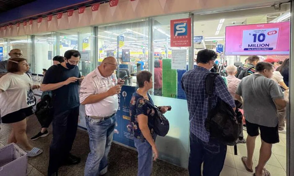 People queueing to buy Toto tickets at the Singapore Pools outlet at Toa Payoh HDB Centre on July 31.