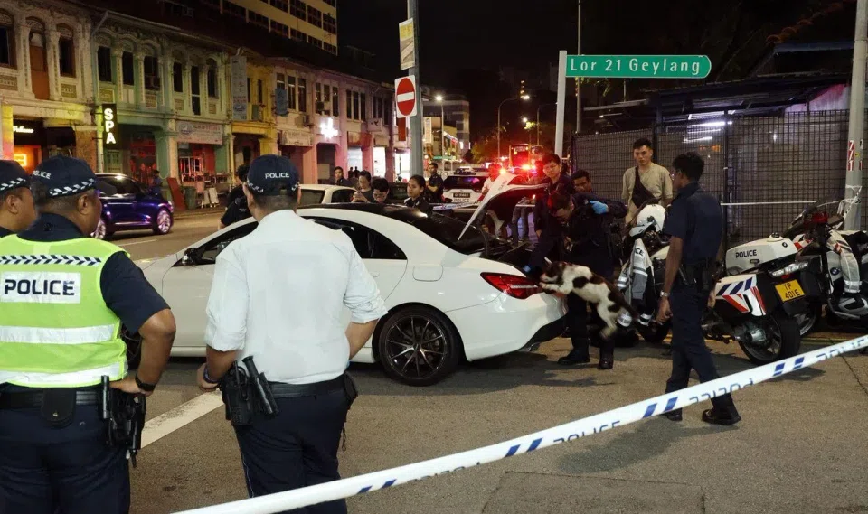 Dashcam footage captured a white car turning into Lorong 21 Geylang. It stopped at the mouth of the street before three people dashed out of the vehicle.