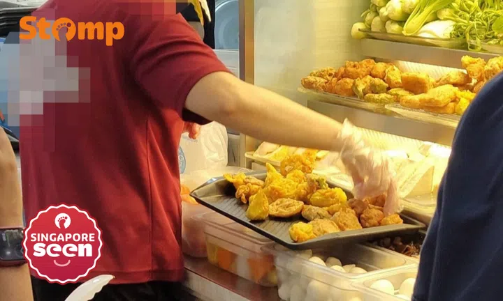 Ubi stall employee puts yong tau foo ingredients on tray