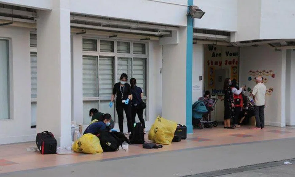 Police officers near where a woman was found lying motionless with multiple stab wounds at the void deck of Block 308 Jurong East Street 32. PHOTO: LIANHE ZAOBAO