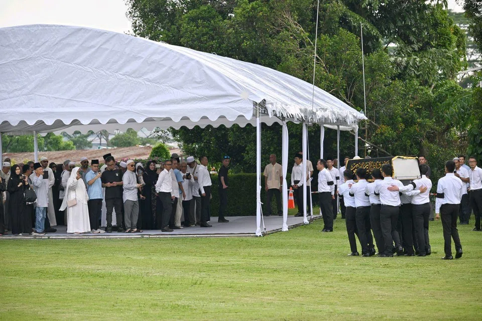 The casket of Puan Noor Aishah being carried by pallbearers at Kranji State Cemetery on April 22.