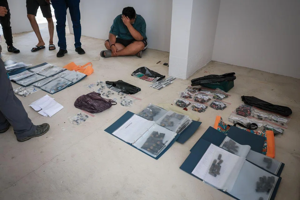 HSA officers detaining Jodan Chin Wei Liang (in green shirt) at a carpark in Bishan Street 13 on July 10 during a sting operation targeting vaping offences.