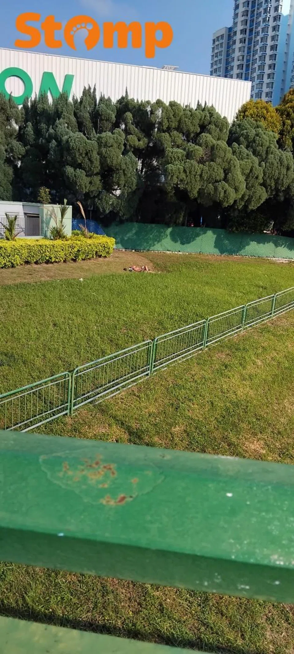 Man sunbathing in his underwear by Kallang River