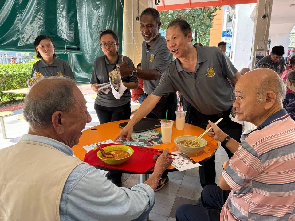 The Singapore United Party deputy-secretary general Darren Soh (right) with party chairman Dr Ridhuan Chandran (second from right) speaking to residents at Chong Boon Market and Food Centre on April 6.