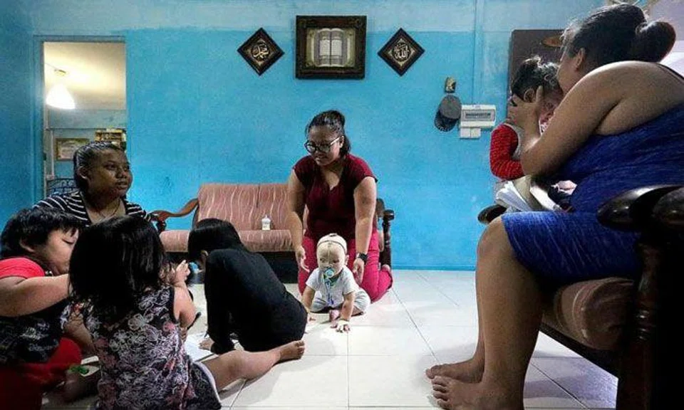 Miss Nurul Asyiqin Buang (centre) and her family in their two-room rental flat. TNP PHOTO: PHYLLICIA WANG