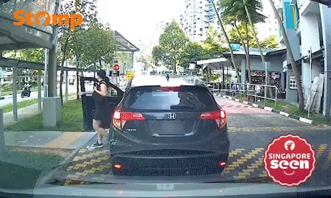 Woman exits car that is blocking the carpark gantry