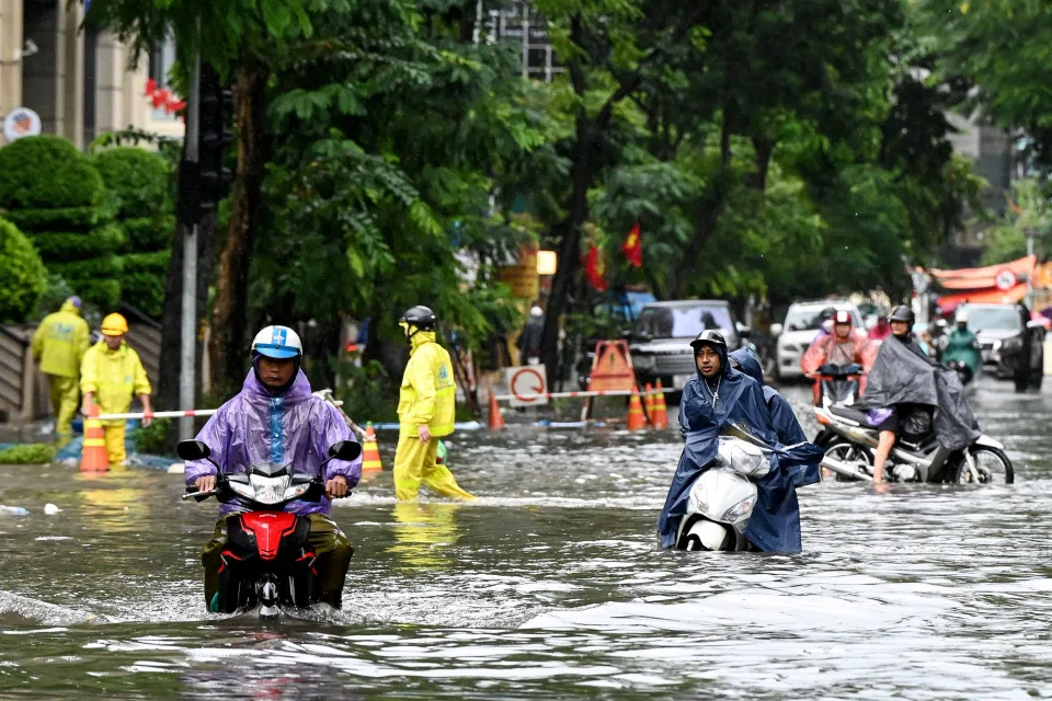 Vehicles drive on a flooded street due to heavy rains caused by Typhoon Matmo in Hanoi on Oct 7.