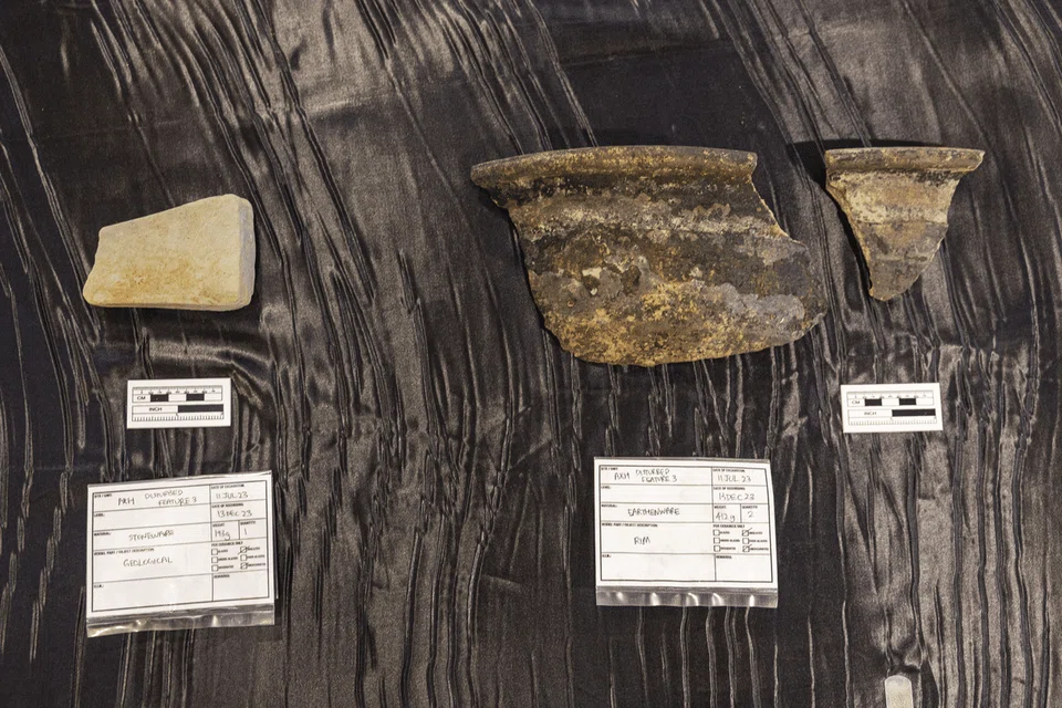 A whetstone (left) and fragments of an earthenware cooking pot (right) were among items found near Block 19 on July 11.