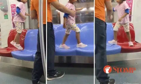 A man stood by as a little girl jumped and walked on the empty seats of an MRT train on the North-East Line.