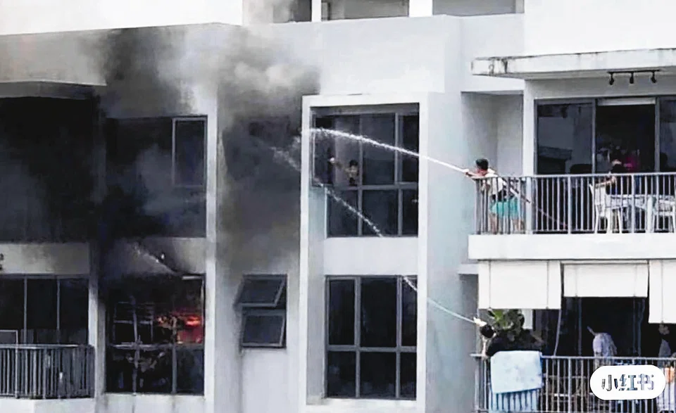 A fire in the same unit in 2020 saw two neighbours trying to put out the flames with a hose. PHOTO: SHIN MIN DAILY NEWS