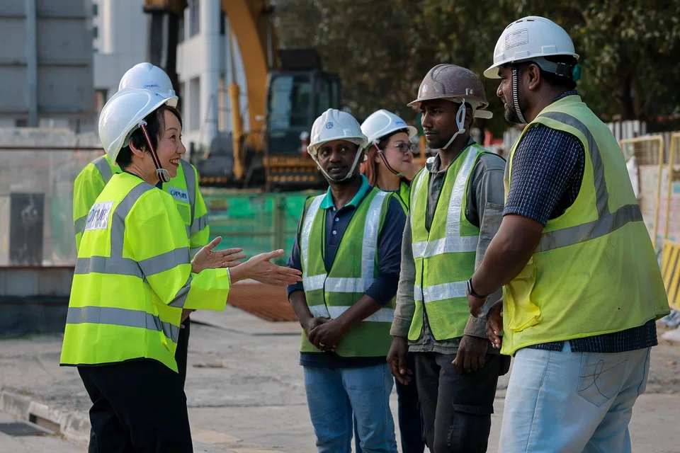 Ms Grace Fu thanking the workers who saved a driver from the sinkhole, Mr Pitchai Udaiyappan Subbiah (centre) and Mr Ganesan Veerasekar (second from right), on July 29.