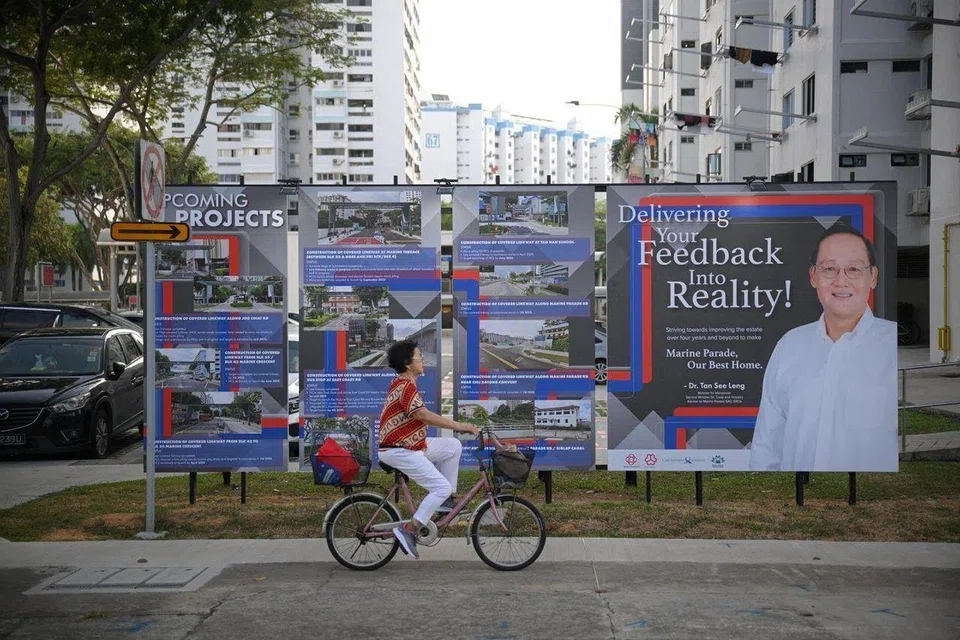 Outdoor boards displaying upcoming projects for Marine Parade GRC next to a poster of Marine Parade MP Tan See Leng.