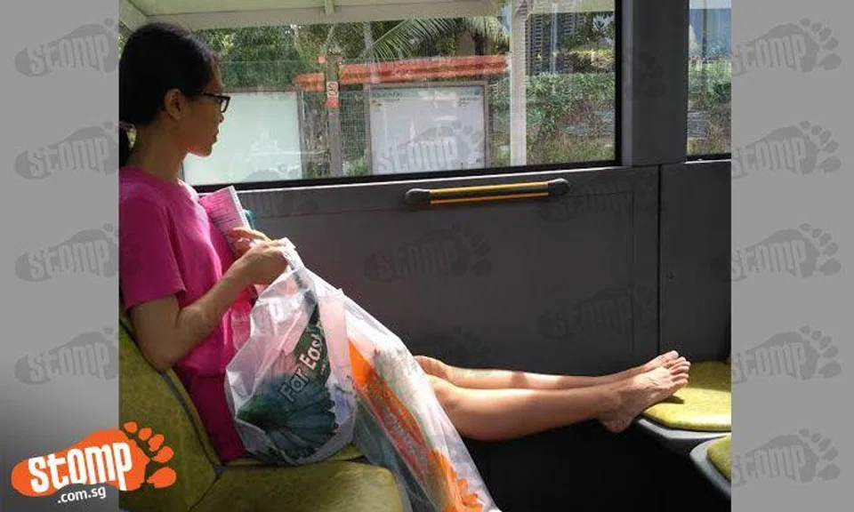 Inconsiderate passenger airs her feet on bus seat