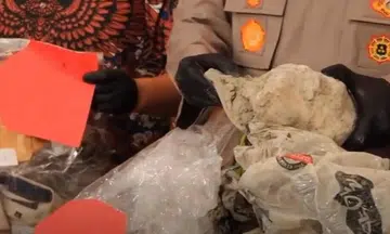 Officers at the Cilacap police station displaying the plastic, cement and sheets the Singaporean victim’s body was found in.