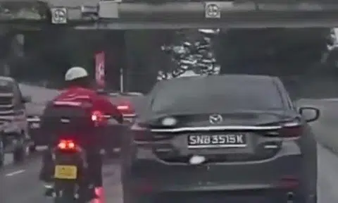 Motorcyclist smacks Mazda driver's side mirror for allegedly blocking him from lane splitting