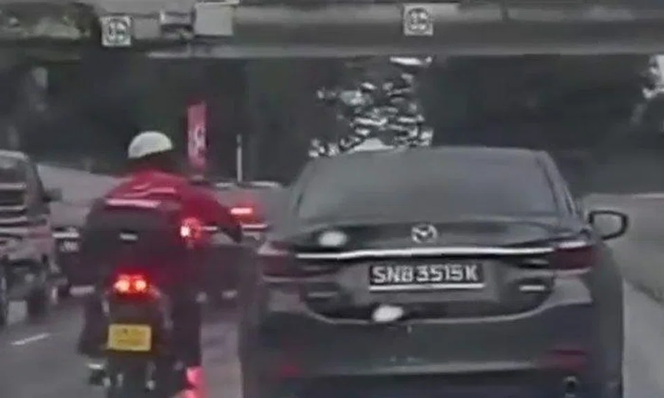 Motorcyclist smacks Mazda driver's side mirror for allegedly blocking him from lane splitting