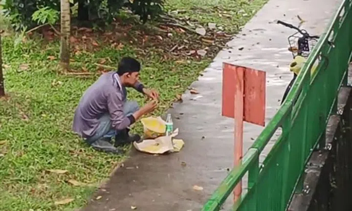 Man squats to eat in the pouring rain: 'It's the life of a foreign worker''It's the life of a foreign worker'