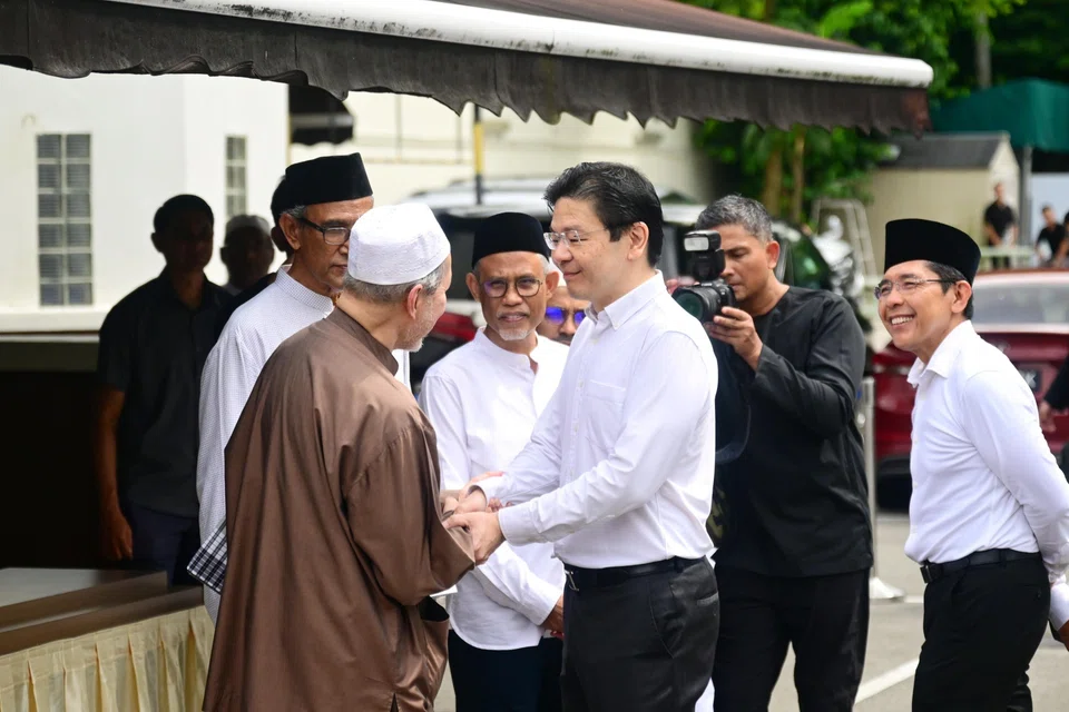 PM Lawrence Wong (right) speaking to Puan Noor Aishah’s son, Dr Imran Yusof Ishak (left), before leaving the funeral at Masjid Ba’alwie on April 22. 
