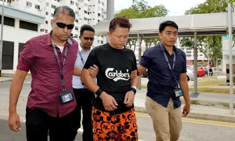 The police escorting Malaysian Khoo Kea Leng, 45, to the scene where he met former City Harvest Church fund manager Chew Eng Han, on Feb 27, 2018.ST PHOTO: KHALID BABA