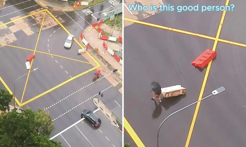 kind pedestrian removes displaced barricades on road