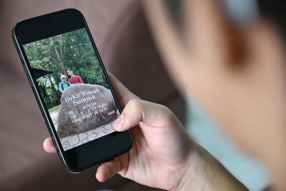 NTU undergraduate Samuel Chew with a photo of him and his late father taken during a trip to Bukit Timah Hill. Chew was a caregiver to his father, who died in October 2025.