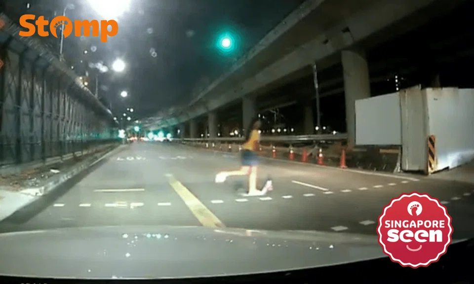 girl rides scooter across red pedestrian light