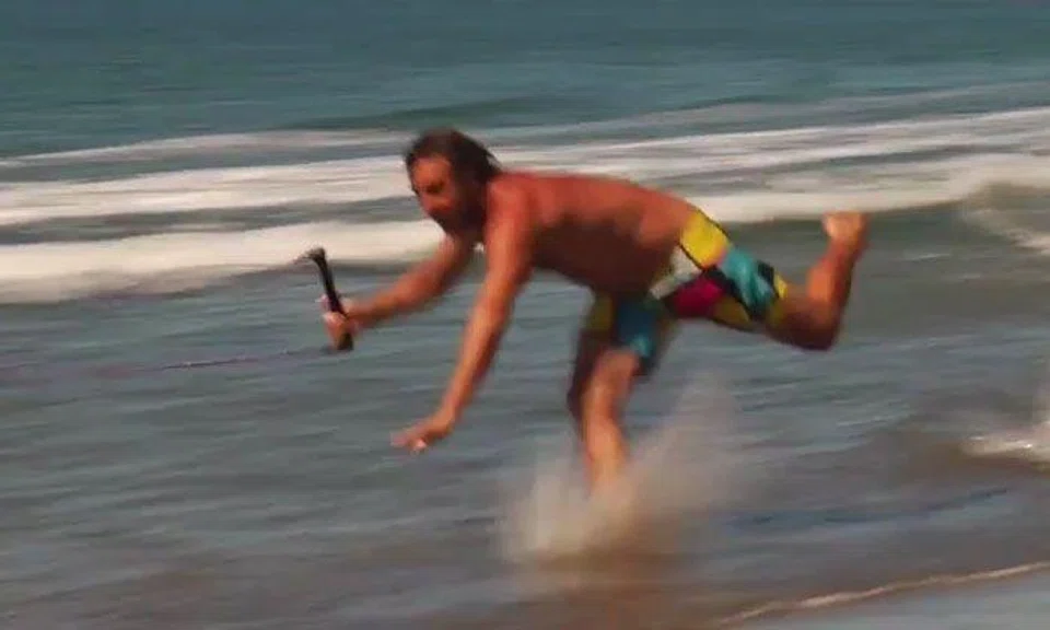 Guy learns the hard way what happens when you 'skurf' too near the shore