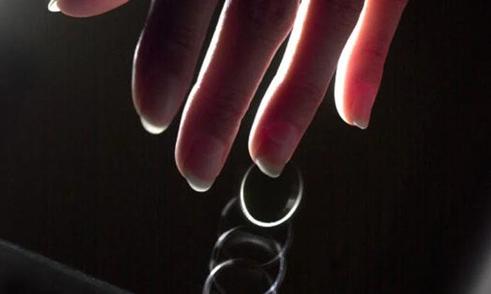 Posed photo of a wedding ring slipping off a finger.