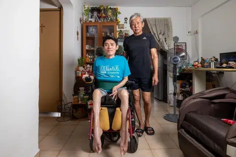 Mr Steven Eng (right), a full-time caregiver to his son William (left), helps him with daily activities such as going to the bathroom and giving him medicine. 