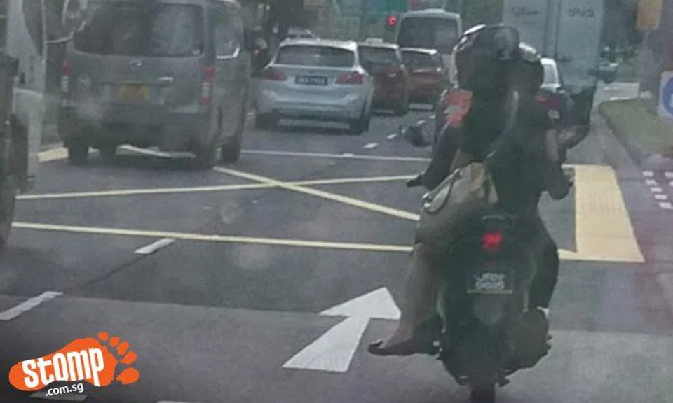 Couple spotted riding side-saddle on motorcycle at West Coast Rd 
